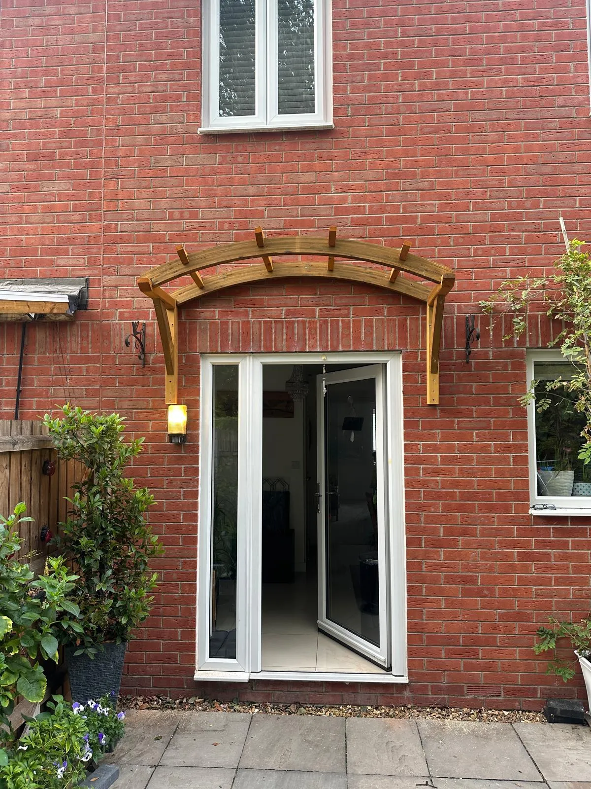 Timber arched door canopy over patio doors