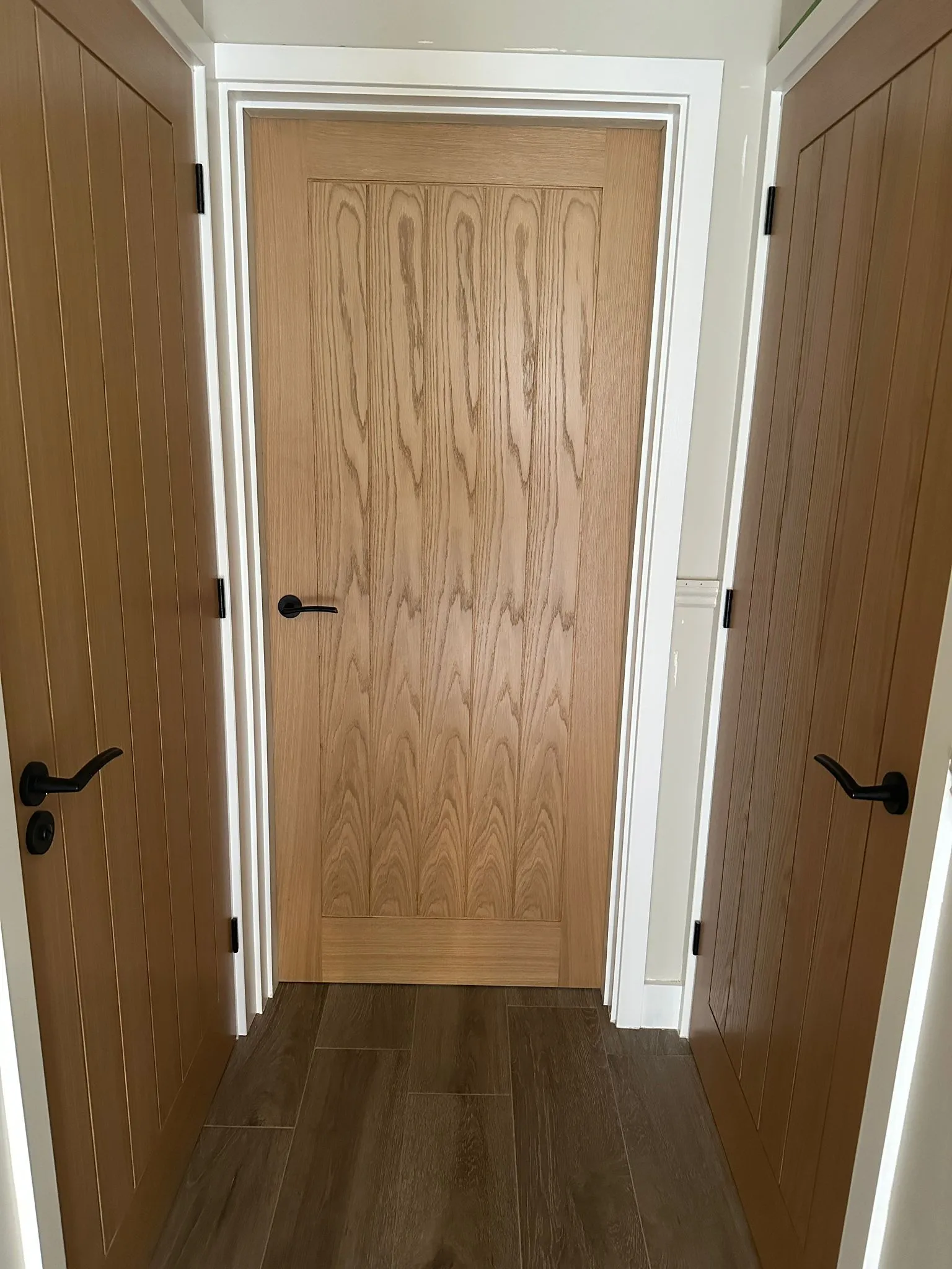 Oak internal doors with black handles in hallway