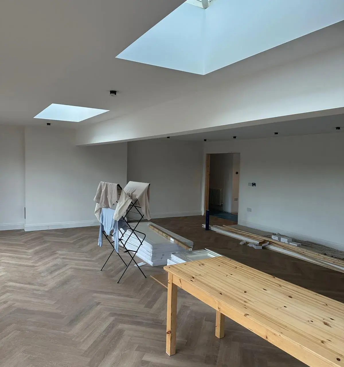 Open plan room with herringbone flooring and skylights