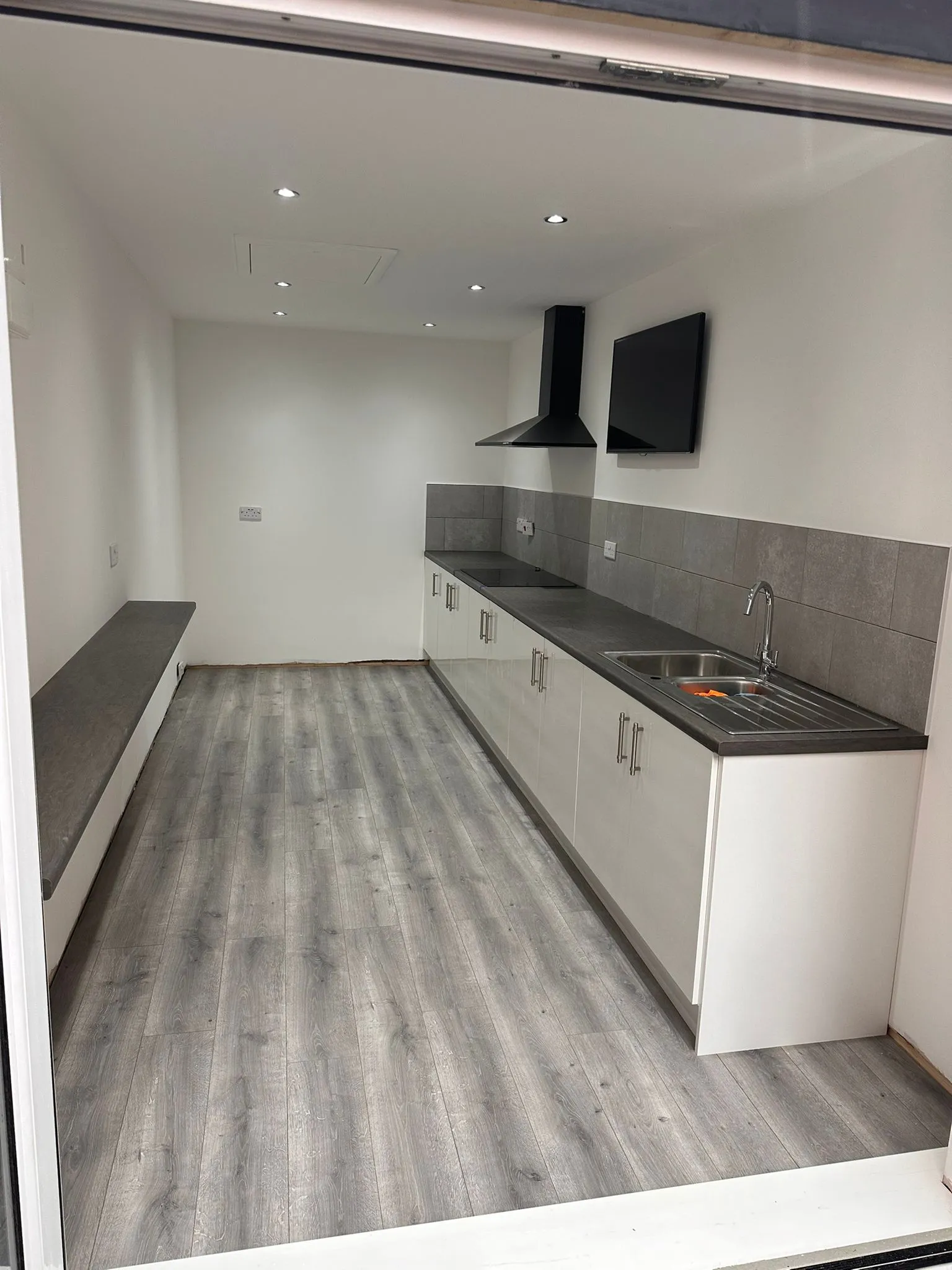 Modern white kitchen with grey worktops and extractor