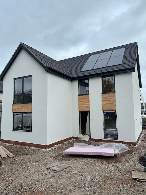 Modern new-build house with white render and solar panels