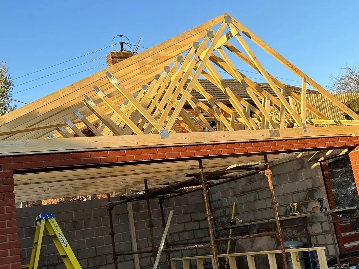 Timber truss roof framework on brick extension