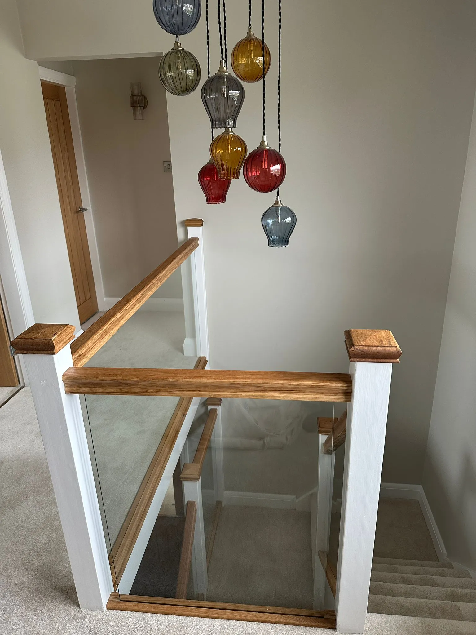 Glass balustrade stairwell view with pendant light cluster