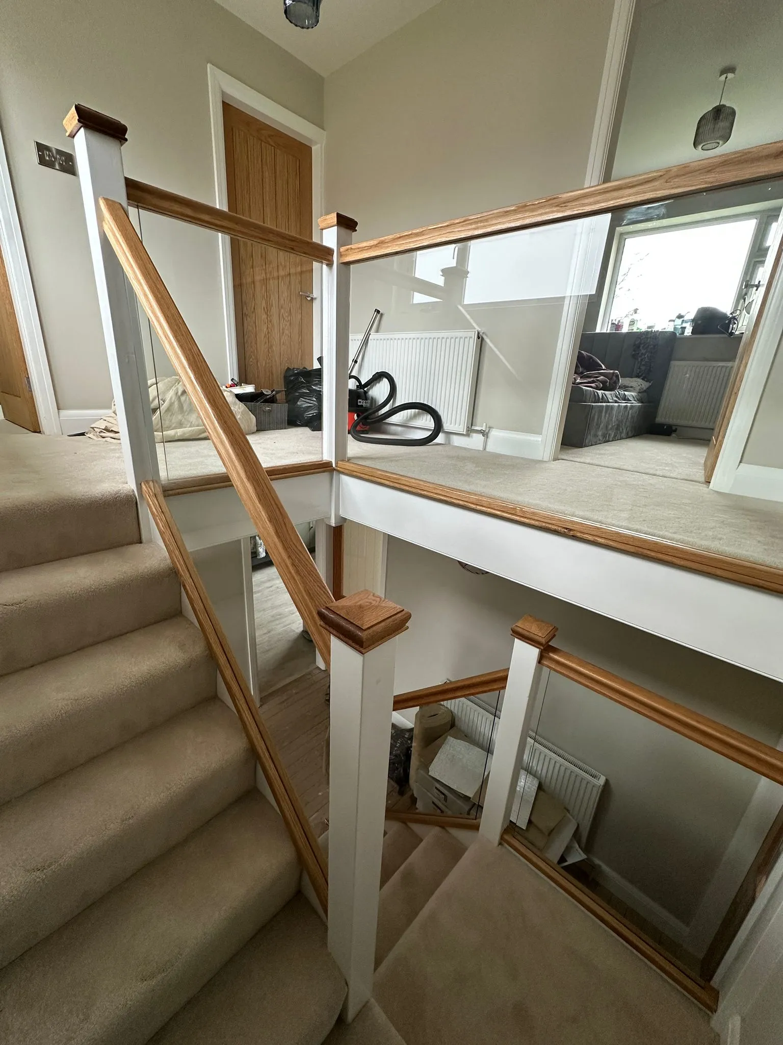 Oak and glass balustrade staircase with carpeted stairs
