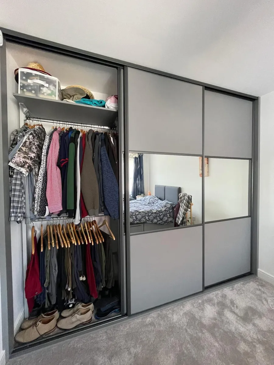 Grey fitted sliding wardrobes with central mirror panel open view