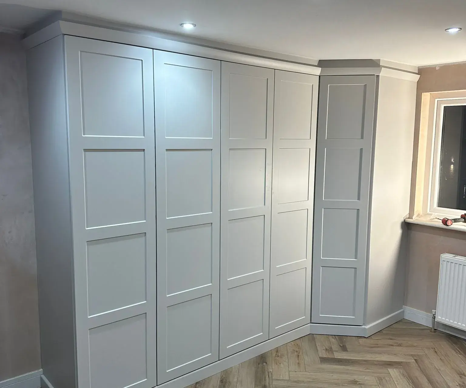 Large fitted grey shaker wardrobes with herringbone floor